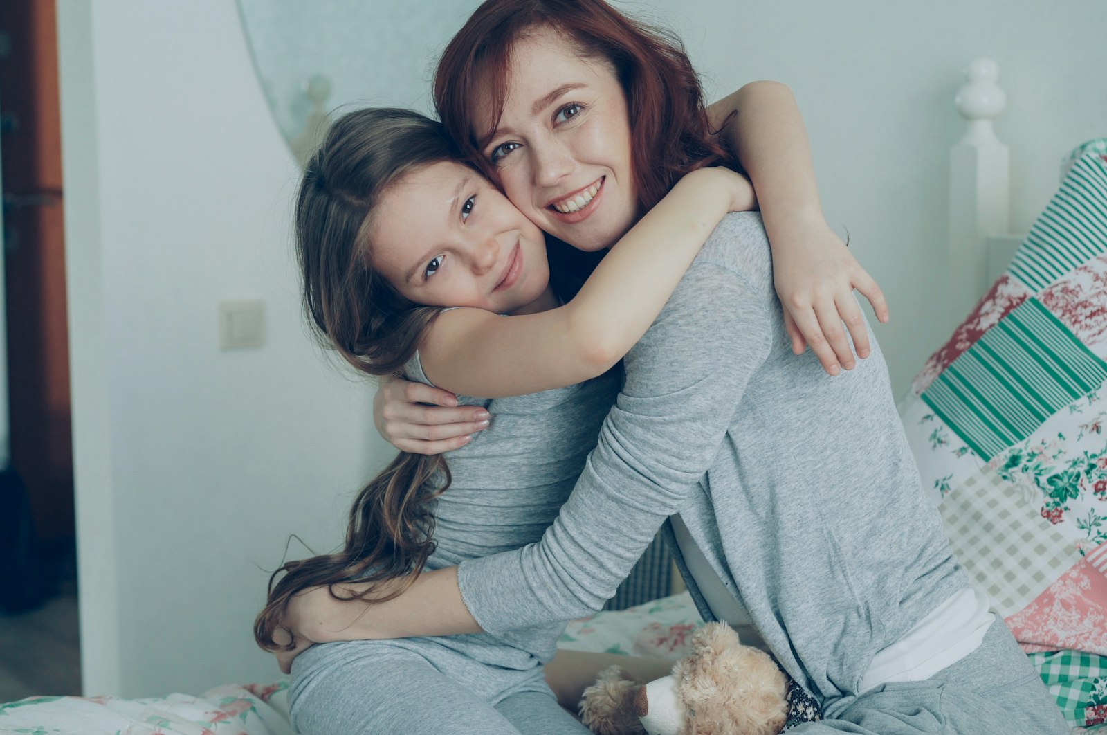 A mother and her daughter sharing a warm hug at home, both smiling